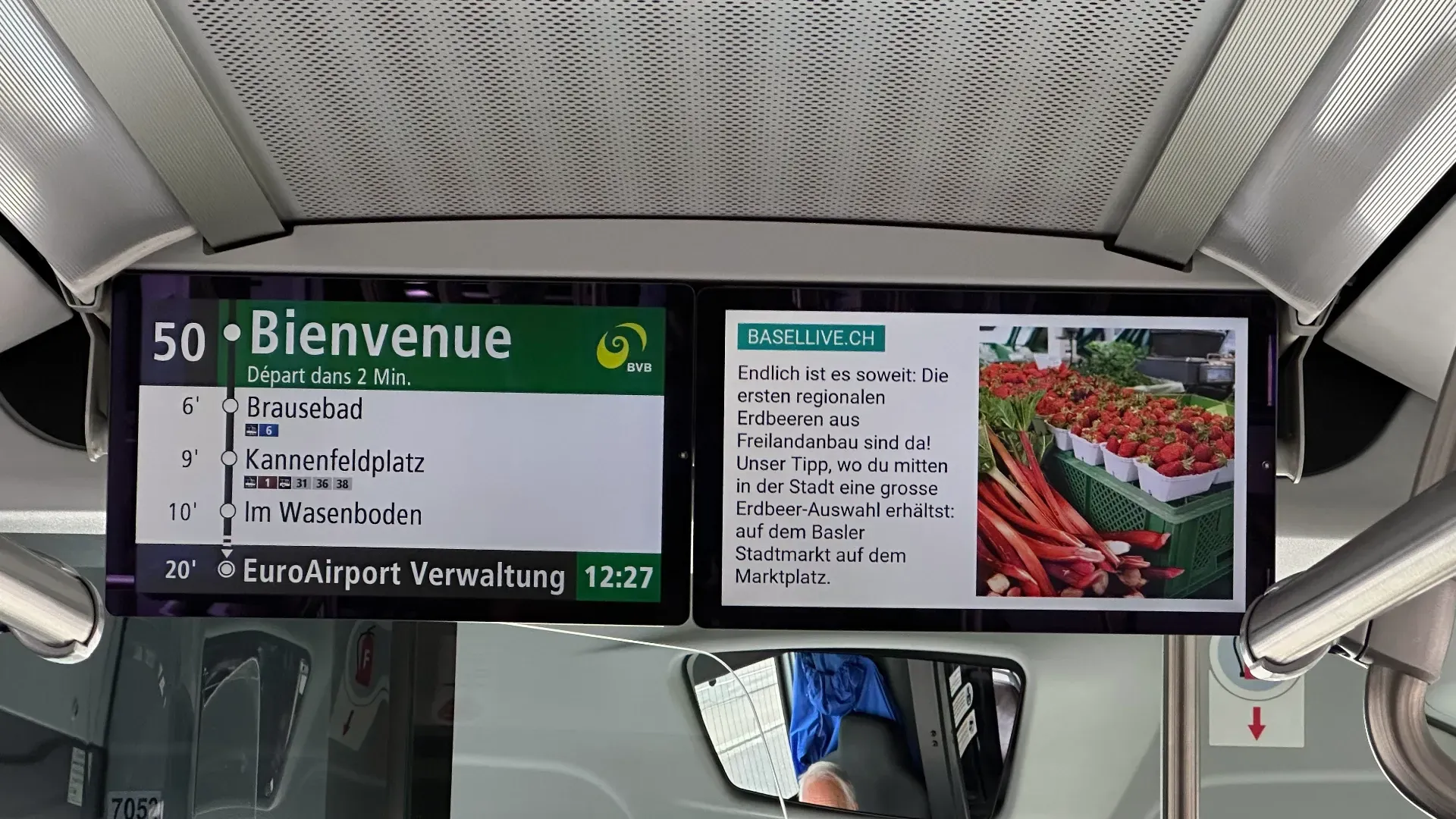 Öffentliche Infotafeln in einer Metro-Station mit Anzeigetafel „Bienvenue“, Haltestellenliste und Uhrzeit, sowie einer zweiten Anzeige mit Text und Bild von Blumen/Beeten.