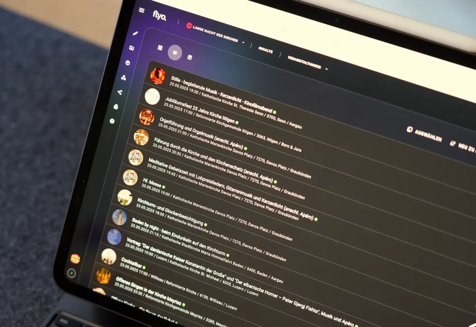 Tablet mit geöffnetem Chat-Interface: mehrere Nachrichtenzeilen mit Profilbildern, Eingabeleiste und Navigationsleiste, im Hintergrund ein Sofa.
