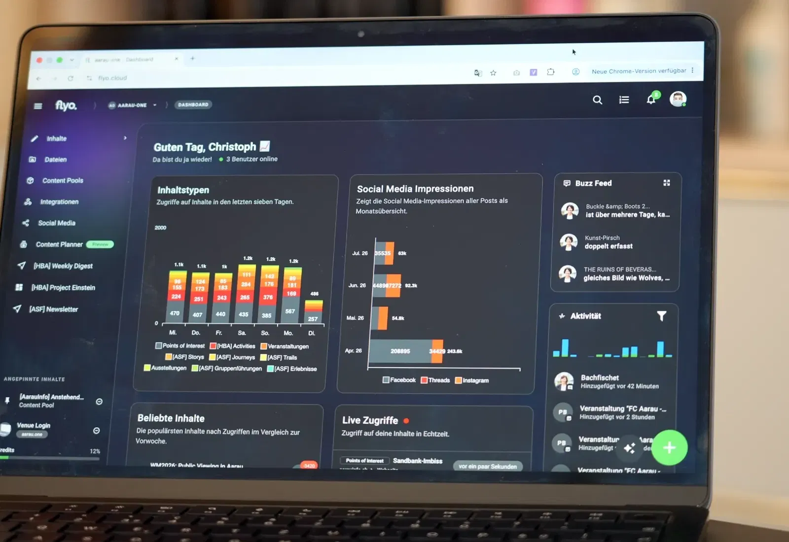 Laptop-Display mit Social-Media-Dashboard: Balken- und Diagrammanzeige, mehrere Module wie „Social Media Impressionen“, „Aktivität“ und „Live Zugriffe“.