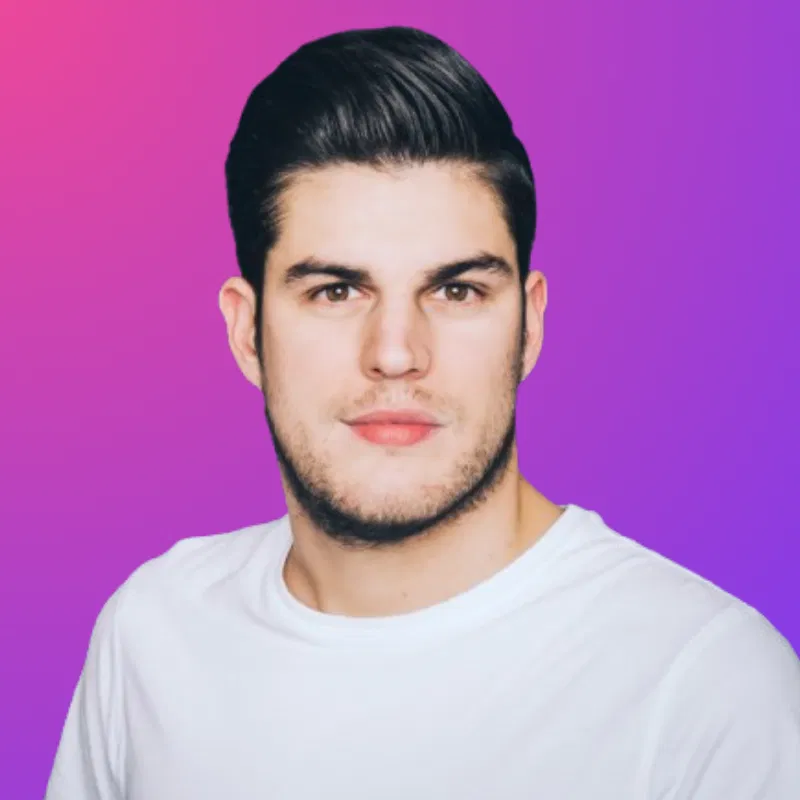 Porträt eines jungen Mannes mit dunklem Haar und Bart in weißem T-Shirt vor pink-violettem Hintergrund.