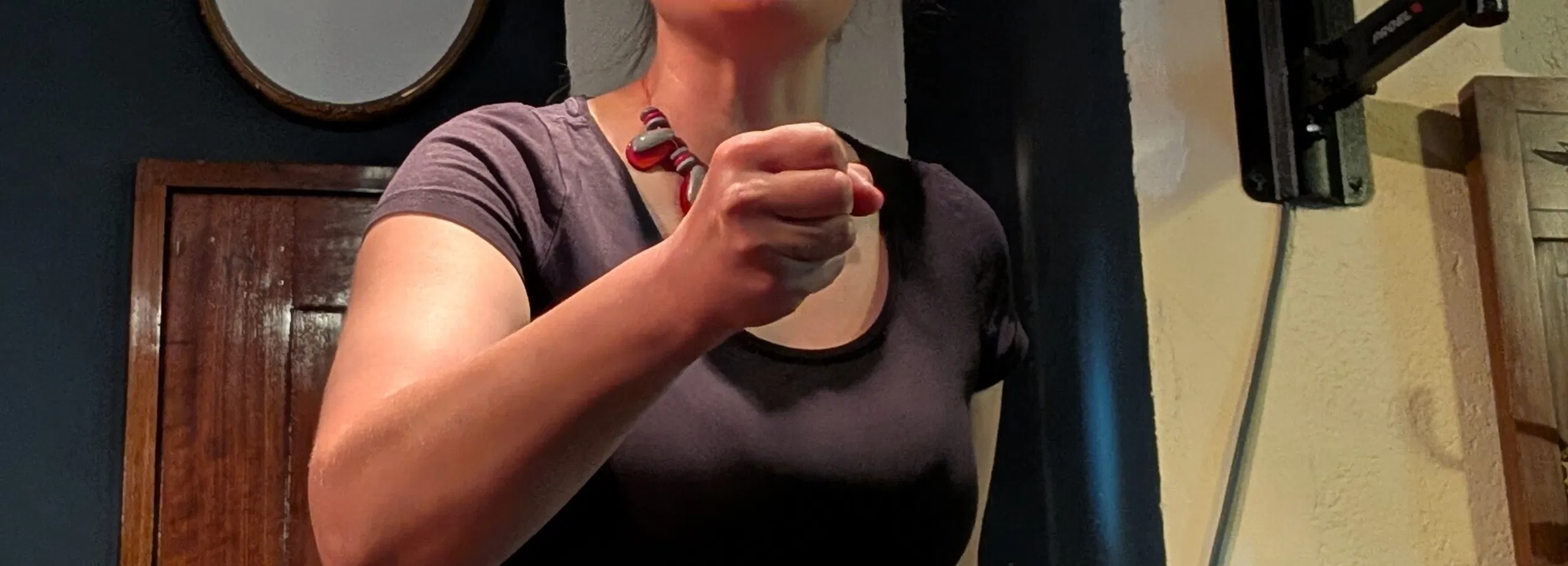 Frau mit Mikrofon in schwarzem Kleid in einer Bar; im Hintergrund ein Schild „Bar Galicia“ und ein Lautsprecher.