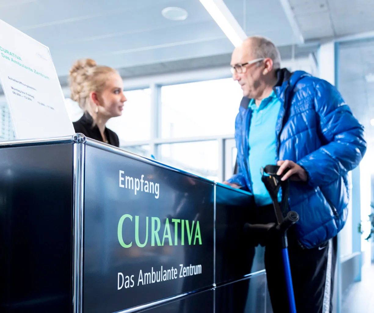 Empfangsbereich mit einem schwarzen Empfangstresen, auf dem das Wort 