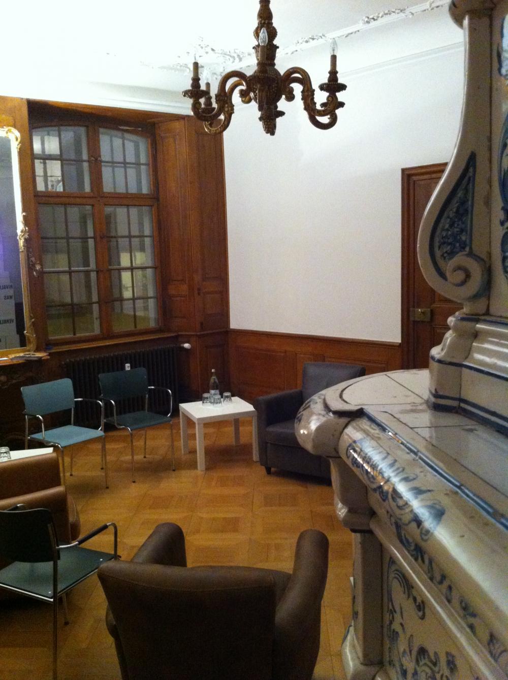 Die Denkpausen finden im Salon vom Ackermannshof statt. Direkt neben dem schönen Porzellanofen.  