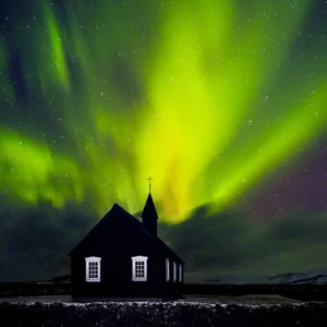 Beautiful bright green Northern light over church, little village in the Iceland, amazing forces of nature, wonderful night sky landscape 